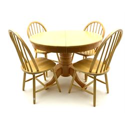 Light wood circular extending dining table and four hoop back chairs