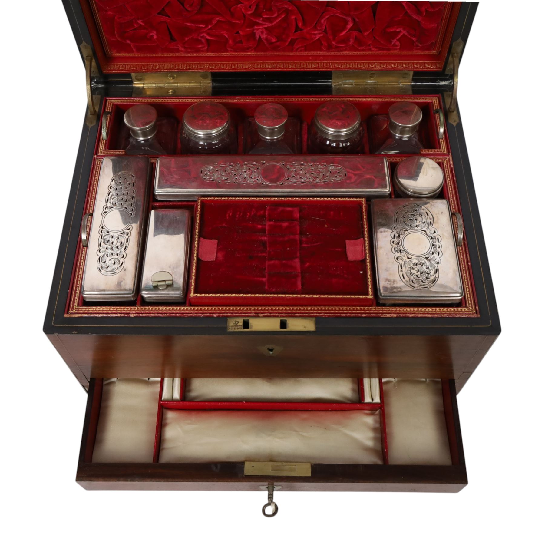  Victorian brass inlaid rosewood dressing table box, retailed by F.L. Hausburg, Liverpool, the lid centred by a brass cartouche, opening to reveal letter store to lid underside, above a fitted interior, with ten mounted cut glass jars, bottles and manicure set, within lift out leather trays, above jewellery drawer, with key, H17cm D24cm