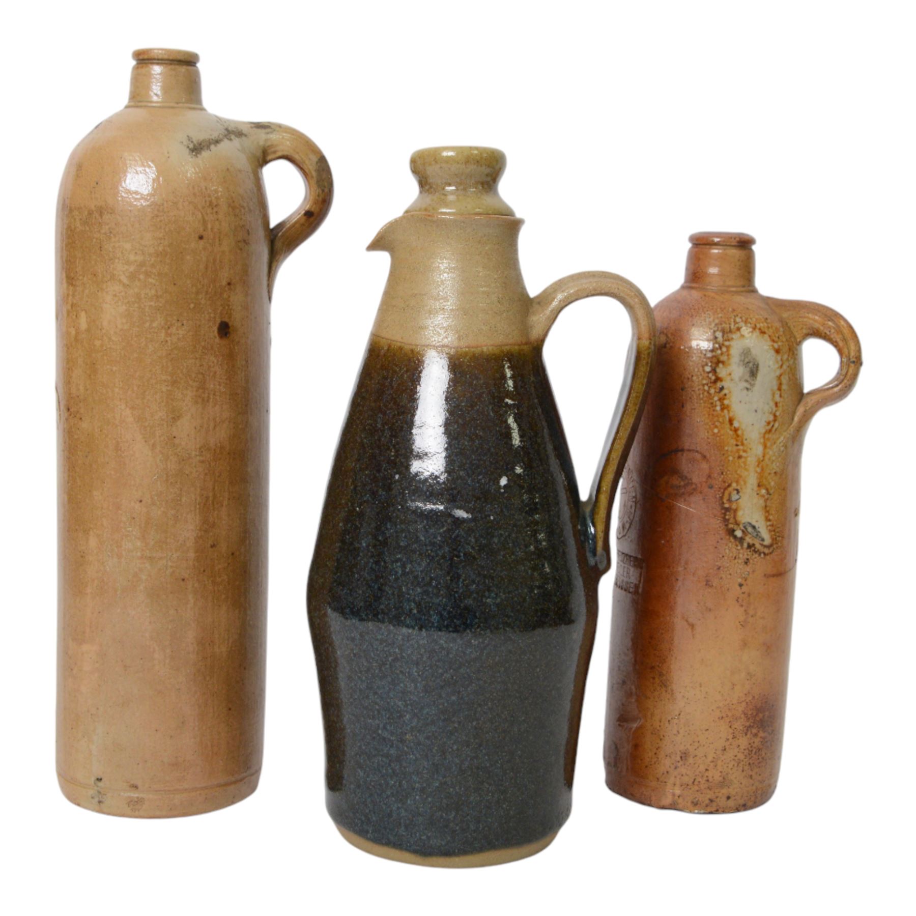 British, a stoneware jug and cover in the manner of Richard Batterham, together with two  stoneware gin flagons 
