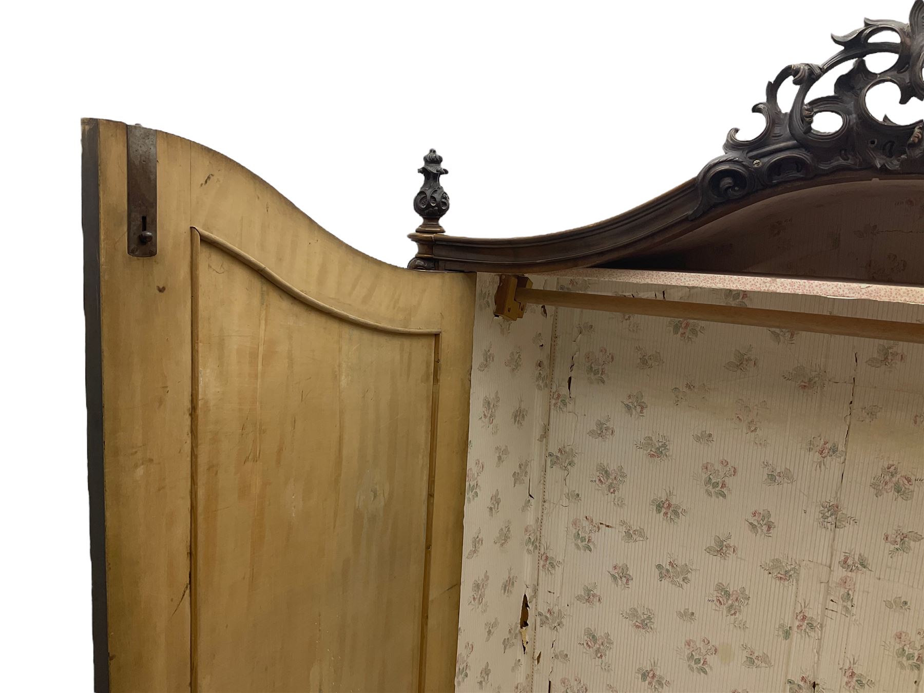 Early 20th century Italian walnut armoire wardrobe, the pierced and scrolling pediment carved with acanthus leaf detail, flanked by two scrolling cartouche with matching corbels below, the two panelled doors with applied carved rinceaux slips, with a central spiral turned upright, enclosing single shelf and hanging rail, raised on scroll feet