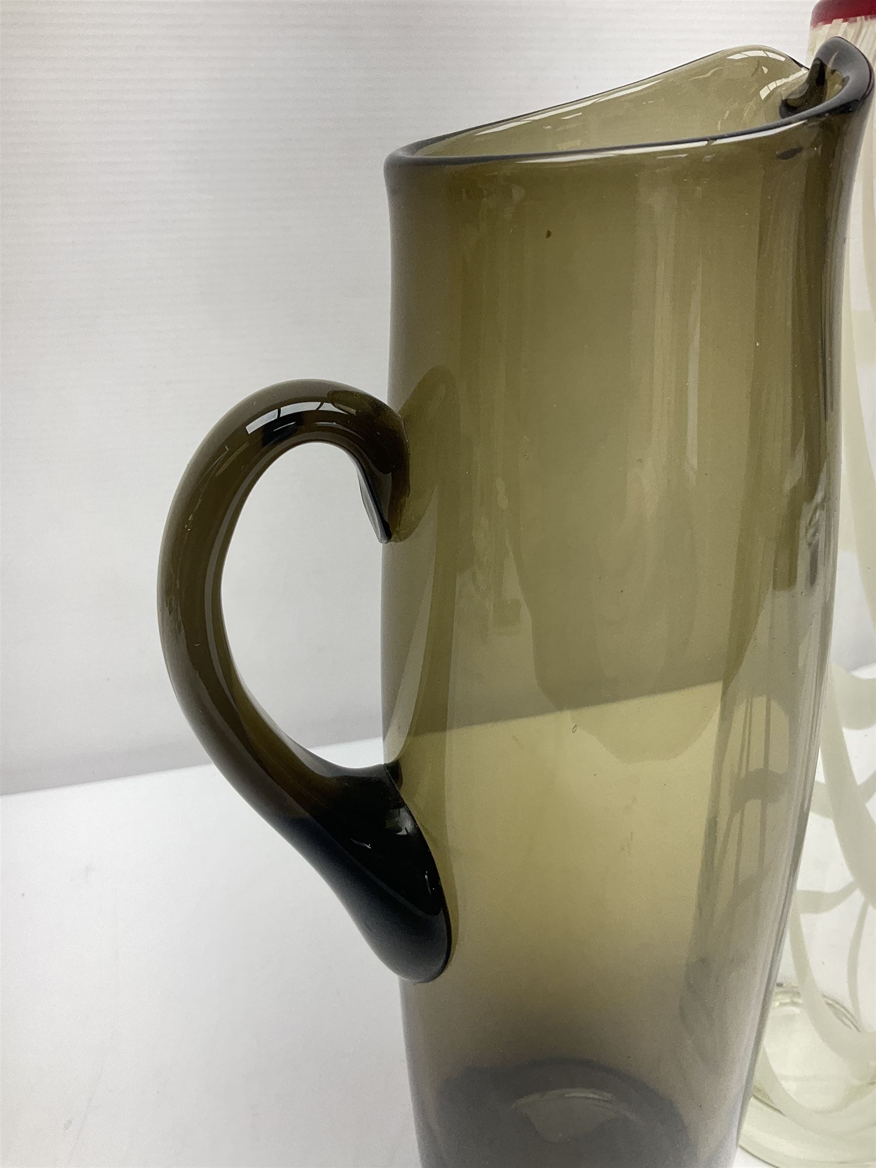 Two Whitefriars glass jugs, together with a Swedish Pukeberg art glass vase and three art glass bowls, including large pink example, some signed to base, tallest H30.5cm