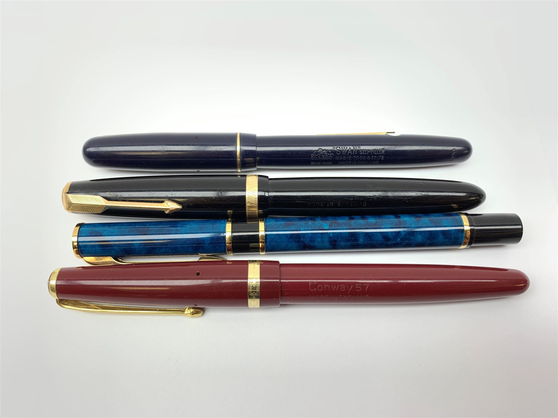 A group of four fountain pens, comprising Parker Duofold, nib marked 14K, Swan Mabbie Todd & Co Ltd Self Filler, nib marked 14C 585, Conway 57, nib marked 14ct, and Waterman Laureat. 