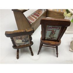 Collection of miniature dolls house grocery shop furniture and produce, comprising glazed corner counter with brass style cash register, shelved preserves unit, pies, cheese board and trays of meats, pair of white cheese counters, biscuit display with six tins, glazed preserves cabinet, pair of shop chairs and four further cheese boards complete with grapes and label flags