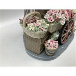 Lladro figure, Flowers of the Season, modelled as a flower seller with cart and baskets profusely decorated with encrusted flowers, beneath an umbrella surmounted with birds, numbered beneath 1454, H27cm
