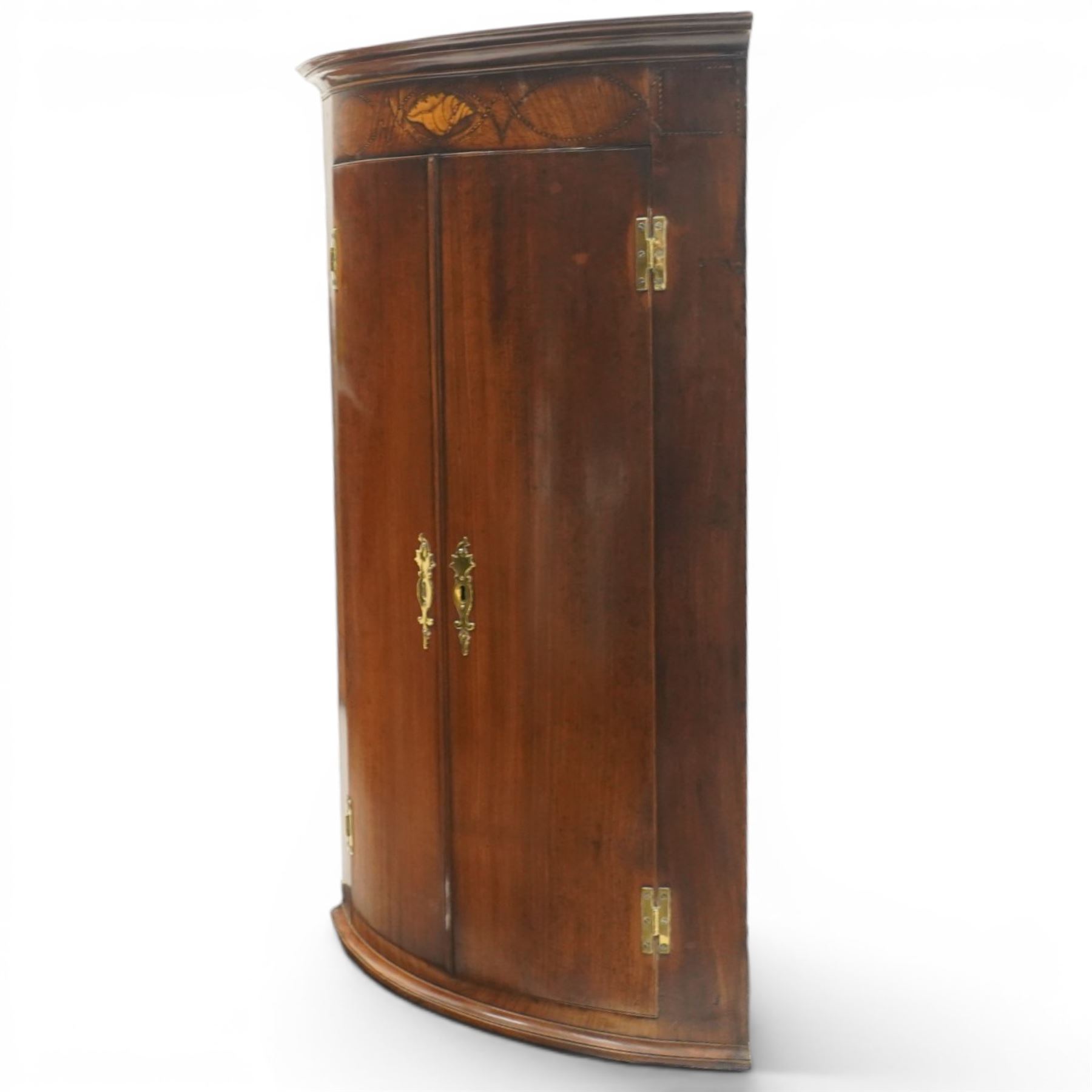 Georgian inlaid walnut cylindrical corner cupboard, projecting cornice over a banded frieze with inlaid shell motif, enclosing three shelves with two spice drawers fitted to base
