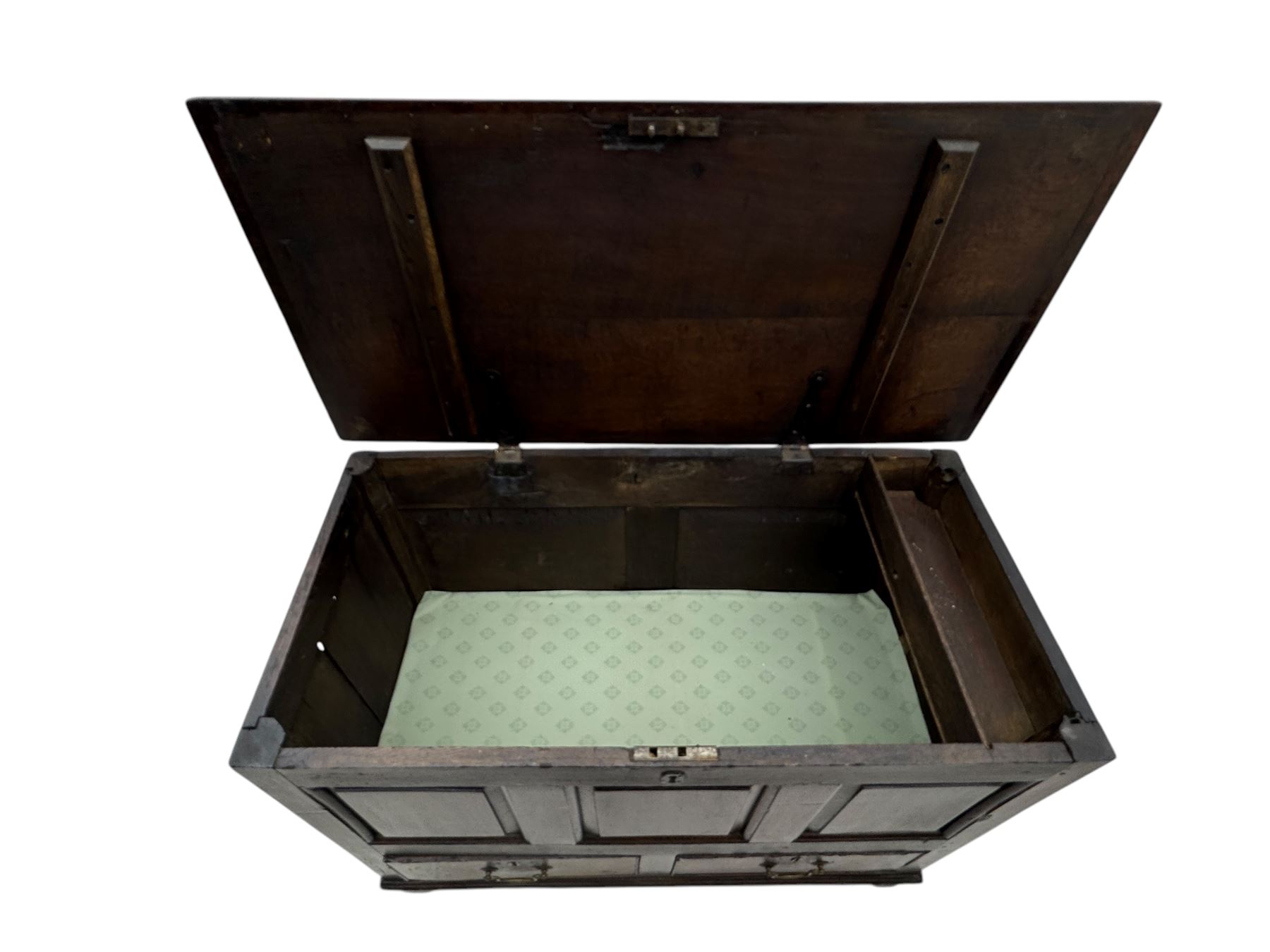 Early 18th century oak mule chest, hinged rectangular top above three recessed panels and two drawers, each fitted with brass drop handles, open interior fitted with candle box compartment, raised on square supports