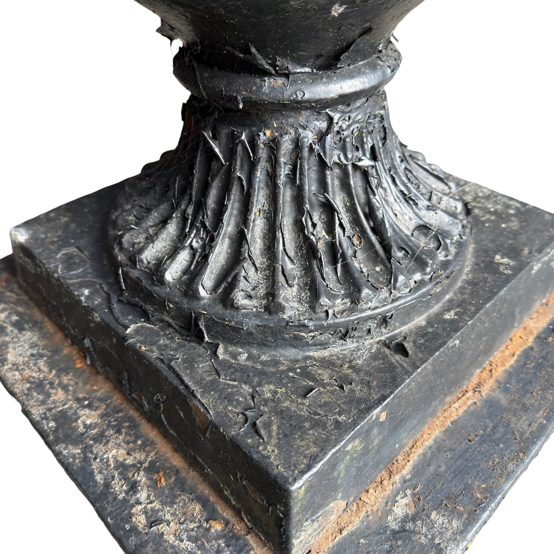 Pair of Victorian cast iron campana form garden urns, the gadrooned flared edge over a scrolling acanthus relief body, with twin male mask handles to each side, over a lobed underbelly with fluted socle, the rectangular pedestals with relief floral garlands and stepped base, in rustic black-painted finish, planted