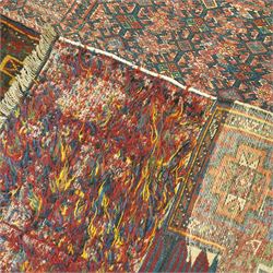 Central Asian vintage saddle cover, probably Turkmen, wool pile and flatweave on wool foundation, decorated with geometric tribal motifs in a palette of madder red, indigo, ivory, and dark brown, with cotton fringe ends 