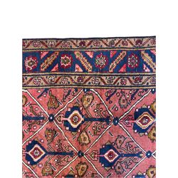 Persian Ardakan crimson ground rug, the field divided by lattice and decorated with stylised tree of life motifs, the border decorated with geometric flower heads, within guard stripes 