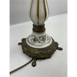 Table lamp in the form of a Victorian oil lamp, the cast metal base with four lion mask and paw feet, leading to a milk glass stem and 'reservoir' with foliate decoration, not including fixtures H68cm, with pleated shade