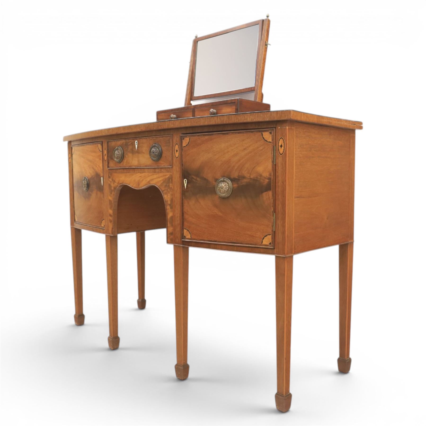 Regency design mahogany bow-front sideboard and dressing mirror, the sideboard with satinwood stringing, central frieze drawer over shaped apron flanked by cupboard doors with oval satinwood line inlaid decoration and circular pressed brass handles, on square tapering supports, the dressing mirror fitted with two drawers to the base (Mirror H 47cm, D 19cm, W 47cm)