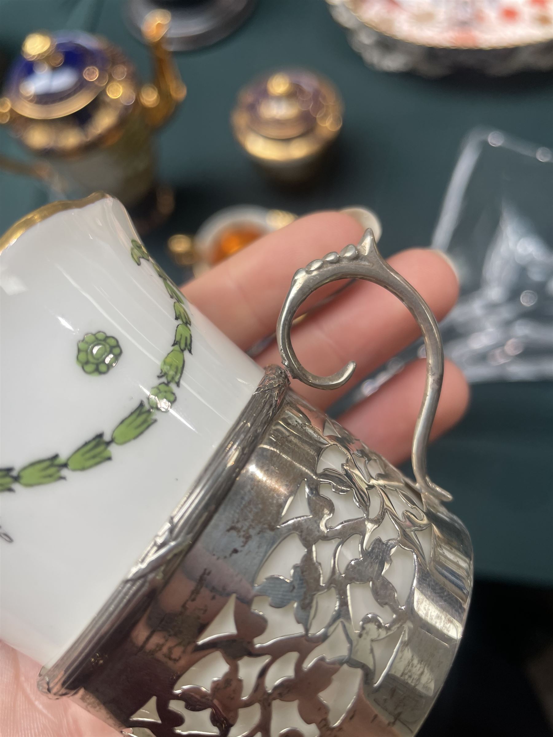 Set of Six Aynsley coffee cans and saucers decorated with garlands, the cans held in pierced silver holders Birmingham 1912 Maker Charles Green & Co and six silver spoons London 1939 Maker Josiah Williams & Co