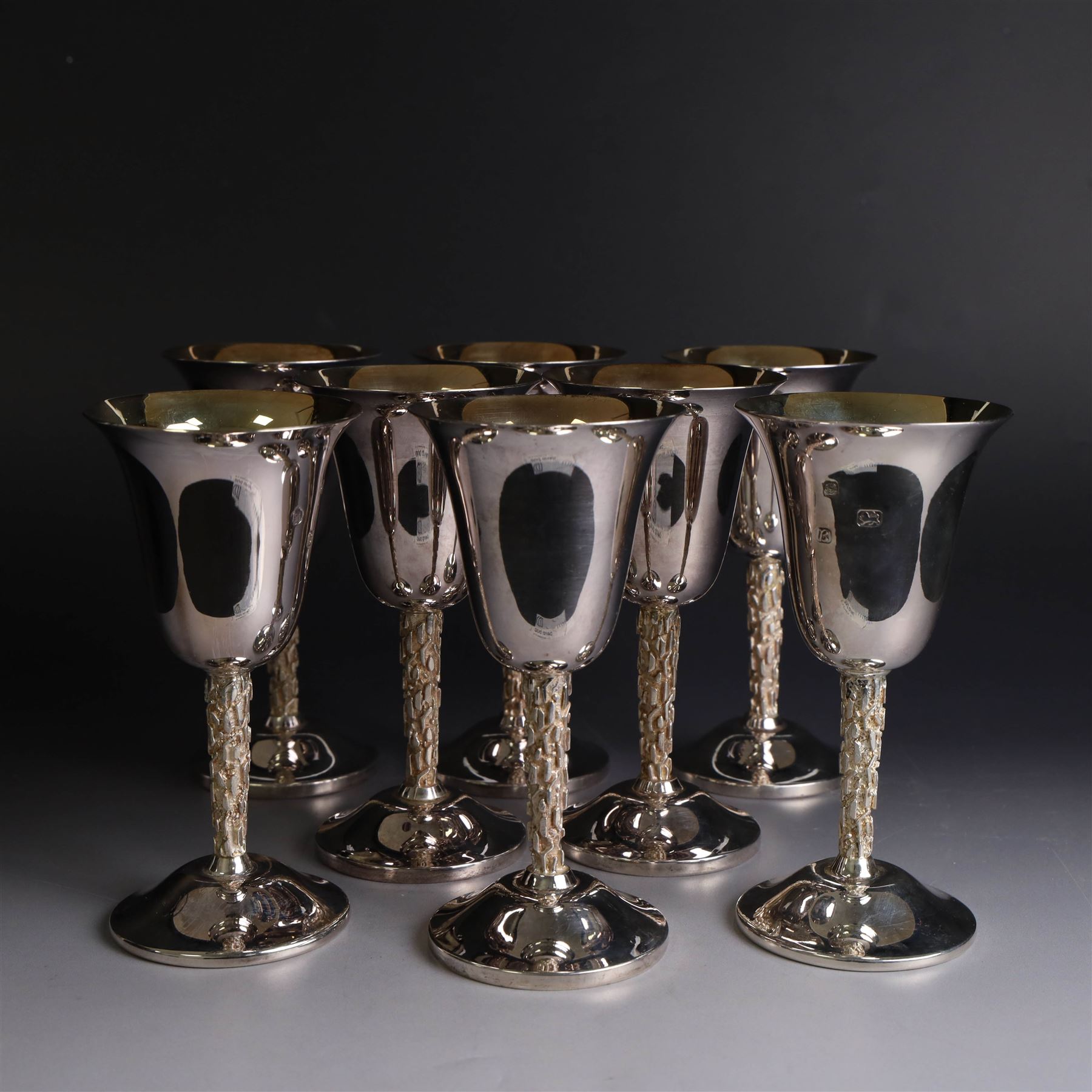 Eight silver goblets, comprising set of six, each plain fluted bowl with gilt interior, upon bark effect stem and domed circular foot, and a pair of very similar examples boxed with large hallmarks to bowls, hallmarked Pinder Brothers, Sheffield 1970 and Sheffield 1976, H14cm