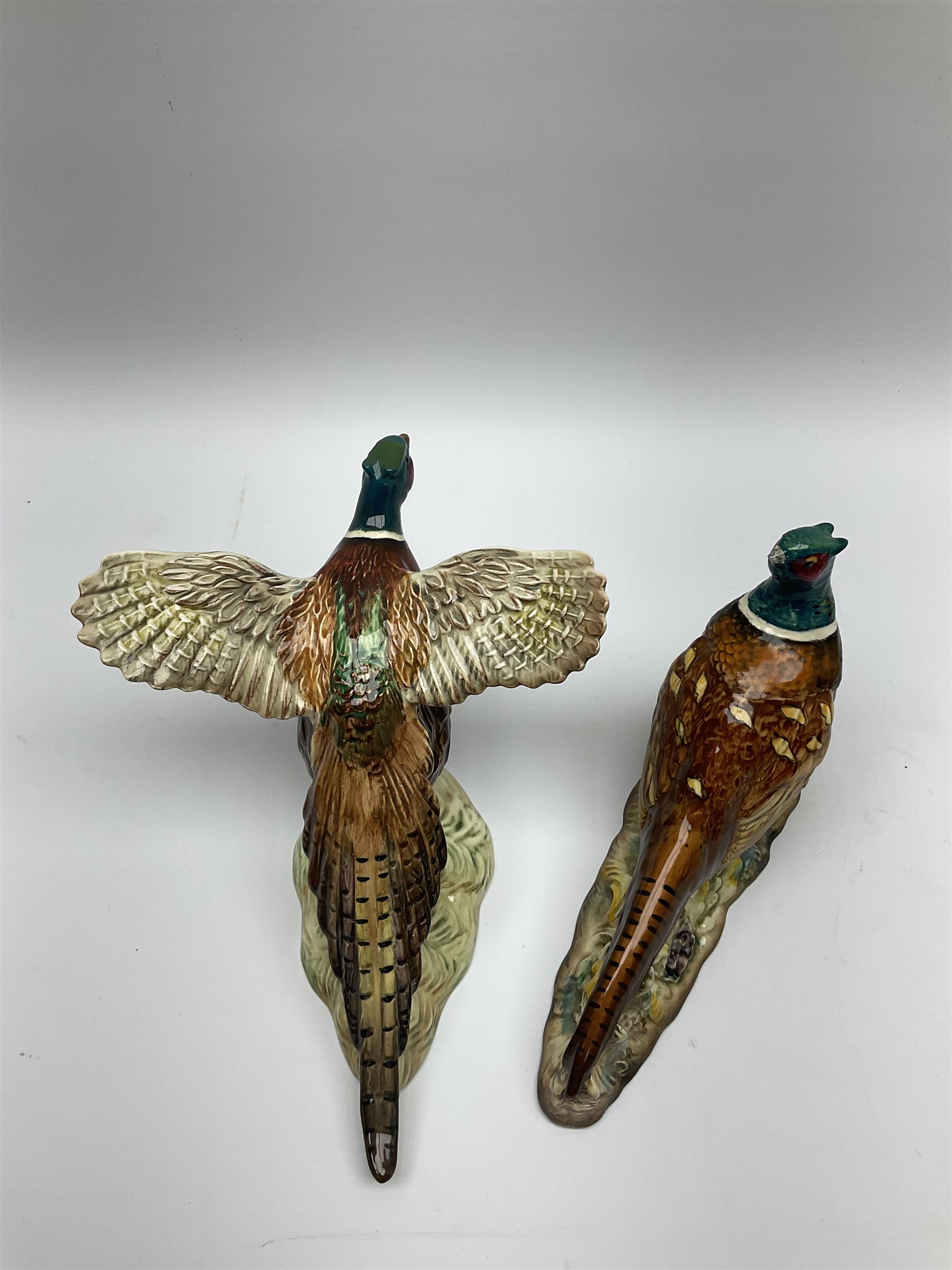 A collection of Beswick figures, comprising ginger cat model no 1898, ginger Persian kitten model no 1886, pheasant in flight model no 849, and pheasant model no 1226b.  