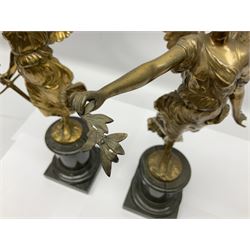After Oswald Schimmelpfennig (German, 1872-1939): Pair of gilt bronze winged Allegorical female figures, the first example with arm outstretched holding a branch, signed 'Schimmelpfennig 1900', the second with arm raised above her head holding a book and sword in the other, both raised upon marble plinths, H45cm