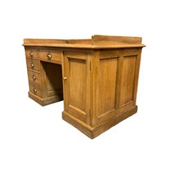 Early 20th century oak ‘Headmasters’ twin pedestal desk, three-quarter raised gallery back and inset leather writing surface, fitted with central drawer flanked by four graduating drawers and single cupboard