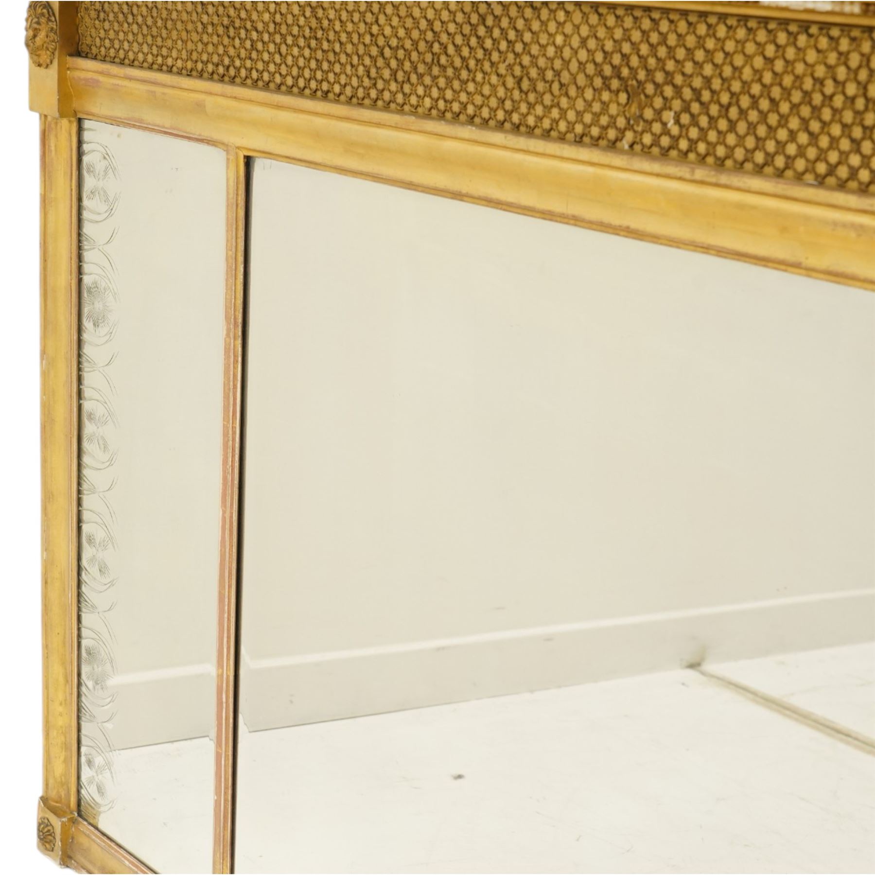 Regency style giltwood and composition tripartite overmantel mirror, rectangular frame with stepped cornice above a pierced geometric frieze, central mirror plate flanked by narrow etched floral side plates, with applied rosette paterae and moulded borders