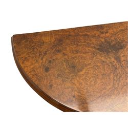 Victorian figured walnut demi-dune card table, the fold-over moulded top with circular baize lining, on four turned pillars with central finial platform, four splayed moulded supports with angular scrolled feet, on castors