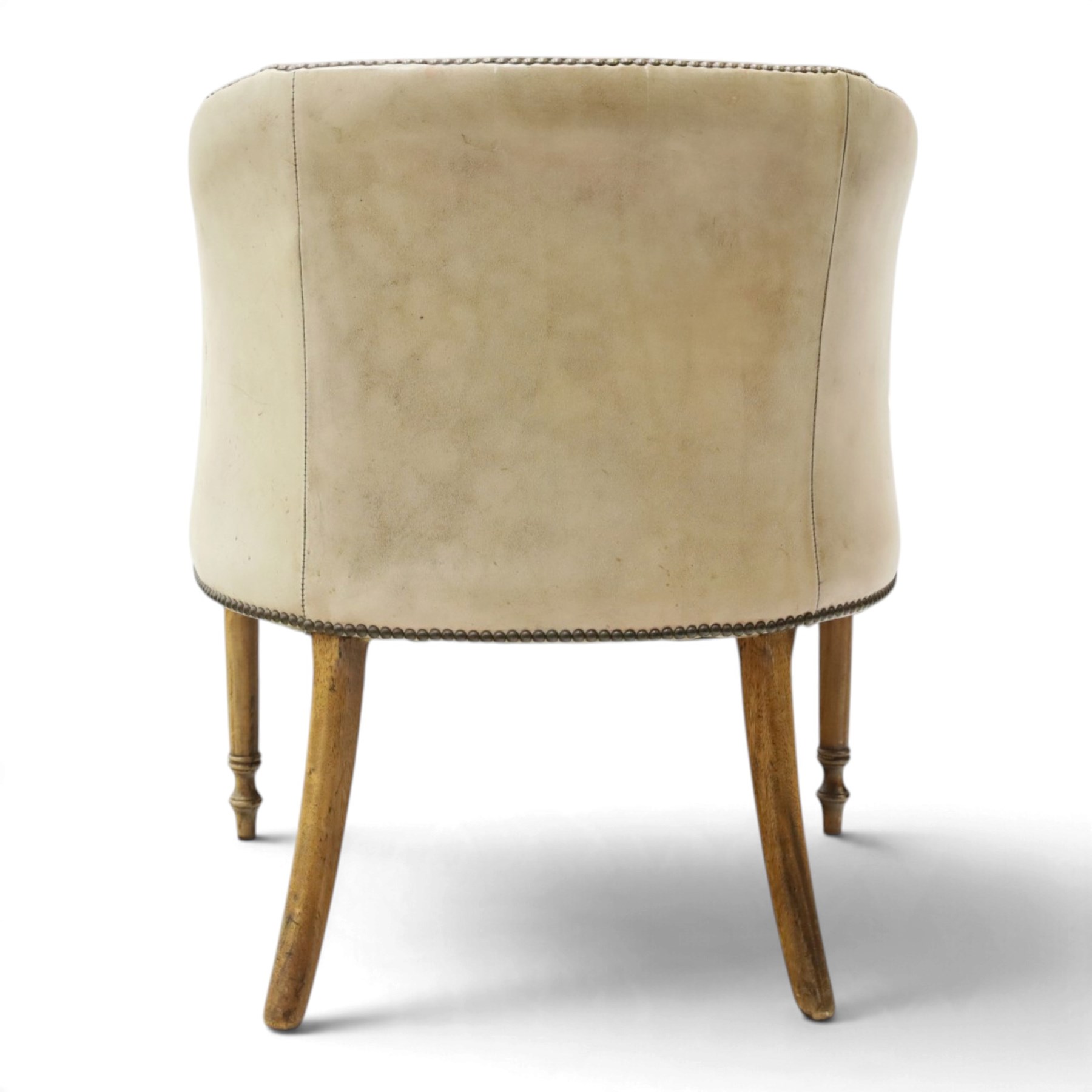 Early 20th century Georgian design mahogany framed desk or club armchair of tub form, with turned pilaster arm supports and legs with rear splayed supports, upholstered in faded tanned leather with loose seat cushion