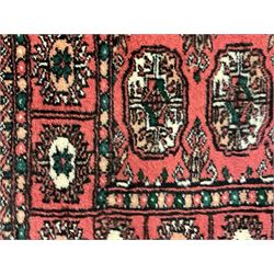 Small peach ground Bokhara rug, decorated with two rows of Gul motifs 