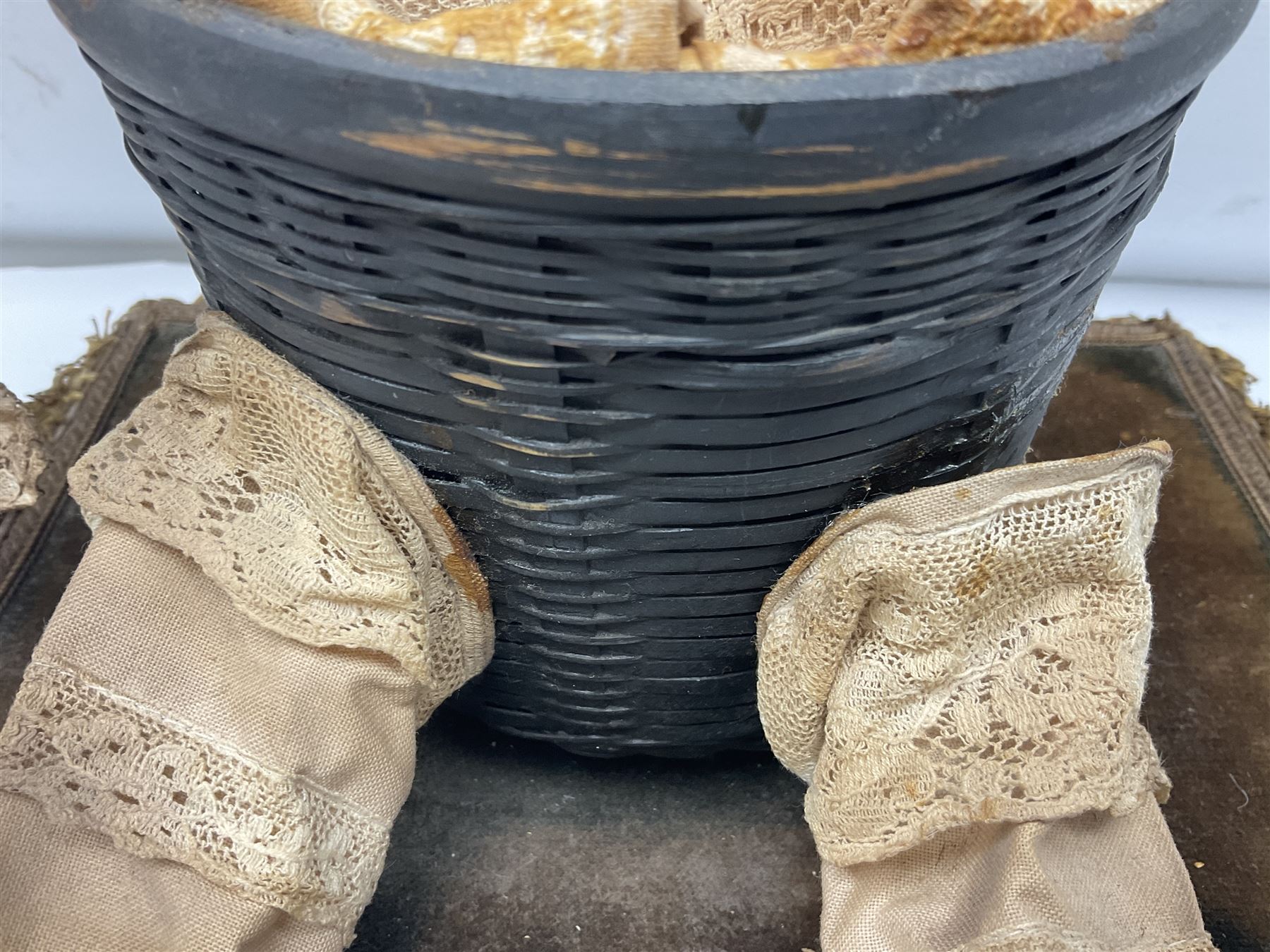 Modern reproduction automaton in the form of a baby doll in a basket clothed in Victorian style lace bloomers and frilled bonnet; clockwork action; on raised platform; with French paper label on base, 29cm wide,