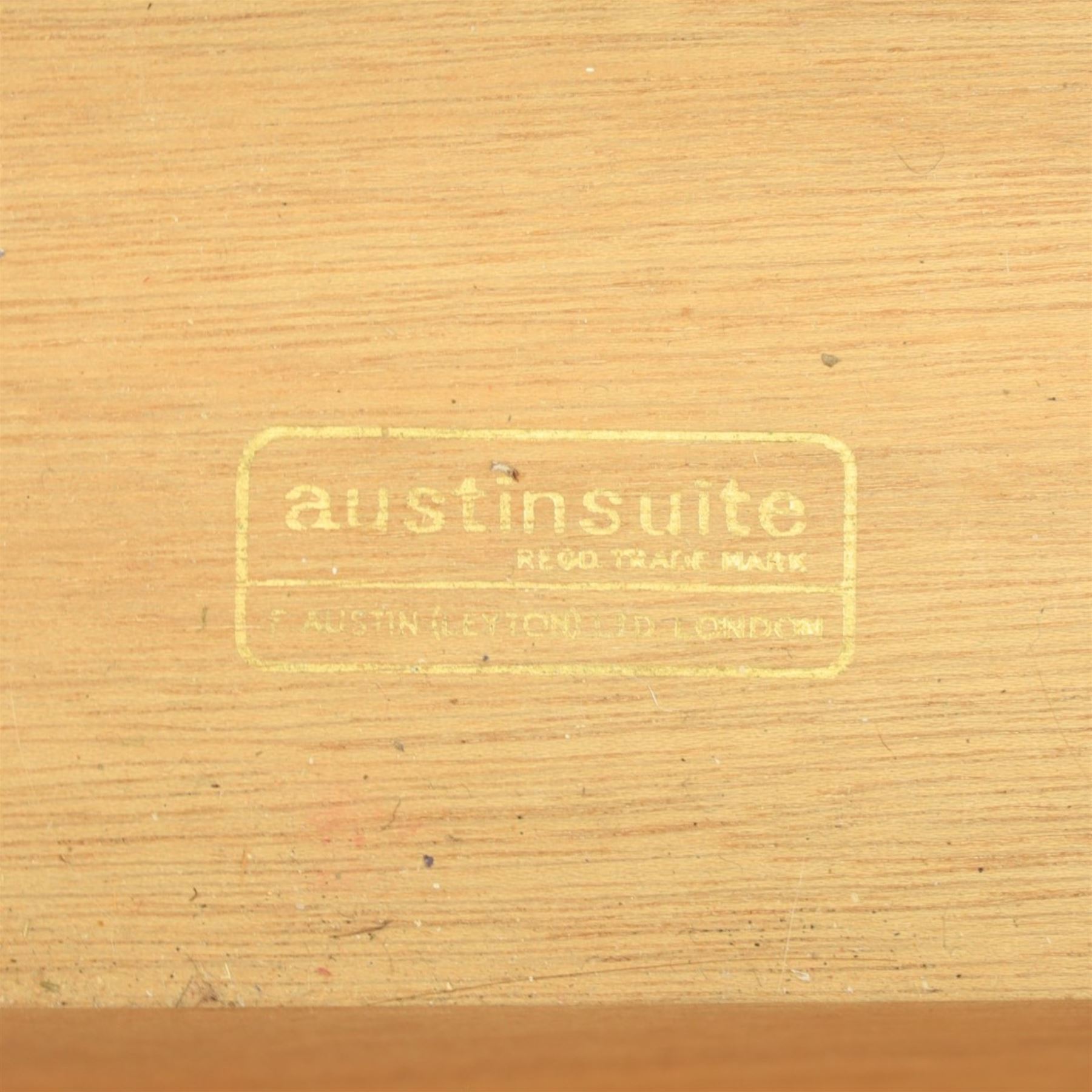 Austinsuite - mid 20th century teak headboard with bedside cabinets and matching  mirrored dressing table, the headboard with floating single drawer bedsides raised on a single tapering support, the dressing table with attached tilting mirror, above rectangular top with kneehole and two banks of two drawers, raised on tapering supports

Headboard H 84cm, D 40cm, W 229cm, W between bedsides 151cm 
Dressing table H 113cm D 44cm, W 149cm, H to underside of dresser 61cm