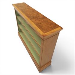 Traditional walnut small bookcase, with projecting cornice above a green painted interior, adjustable shelving, on a moulded plinth base