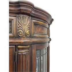 Kevin Charles American walnut demi lune display cabinet with illuminated interior, projecting cornice, two bevel edge glazed doors enclosing two adjustable shelves above single drawer and four cupboard doors with wine rack, carved scrolling supports