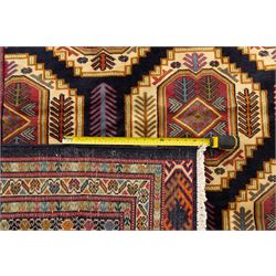 Central Asian Turkmen, main field with octagonal guls enclosing hooked diamond motifs in shades of madder gold, ivory, and indigo set against a dark ground within multiple polychrome borders of geometric devices and stepped motifs 