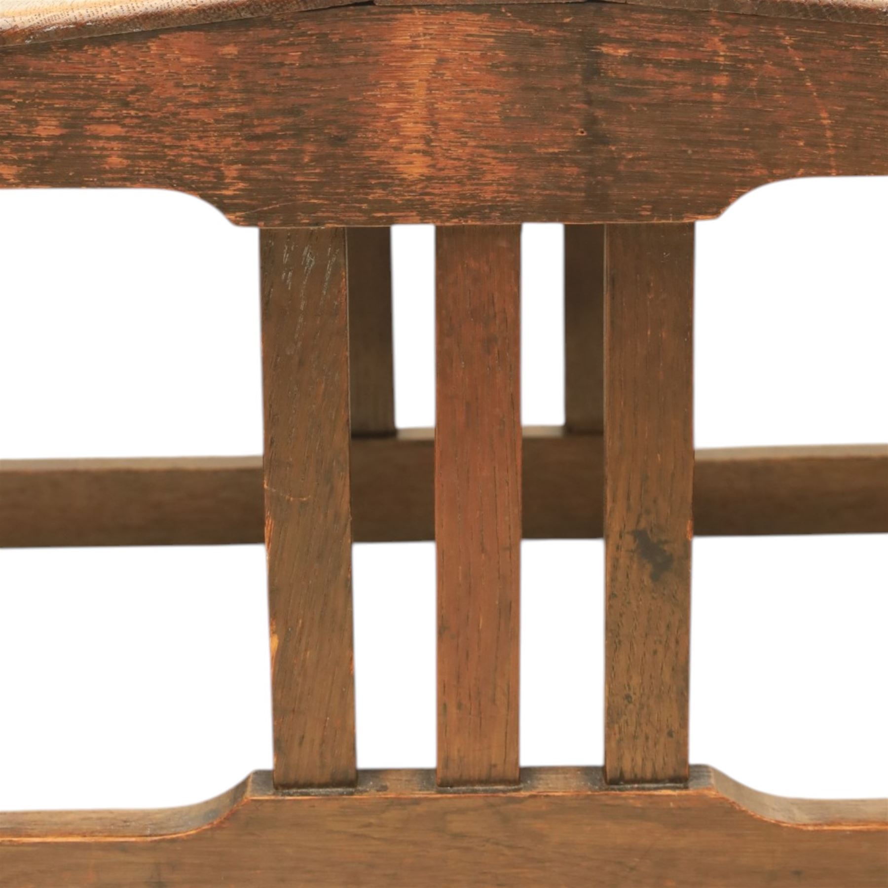 Arts and Crafts oak window bench, with flat armrests flanking two dished seats, raised on square supports united by stretchers