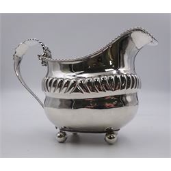 George III silver cream jug, of boat form with fluted band to centre of body, gadrooned rim and acanthus and flower head capped curved handle, upon four ball feet, hallmarked London 1815, makers mark worn and indistinct, H10cm, approximate weight 5.68 ozt (176.7 grams)