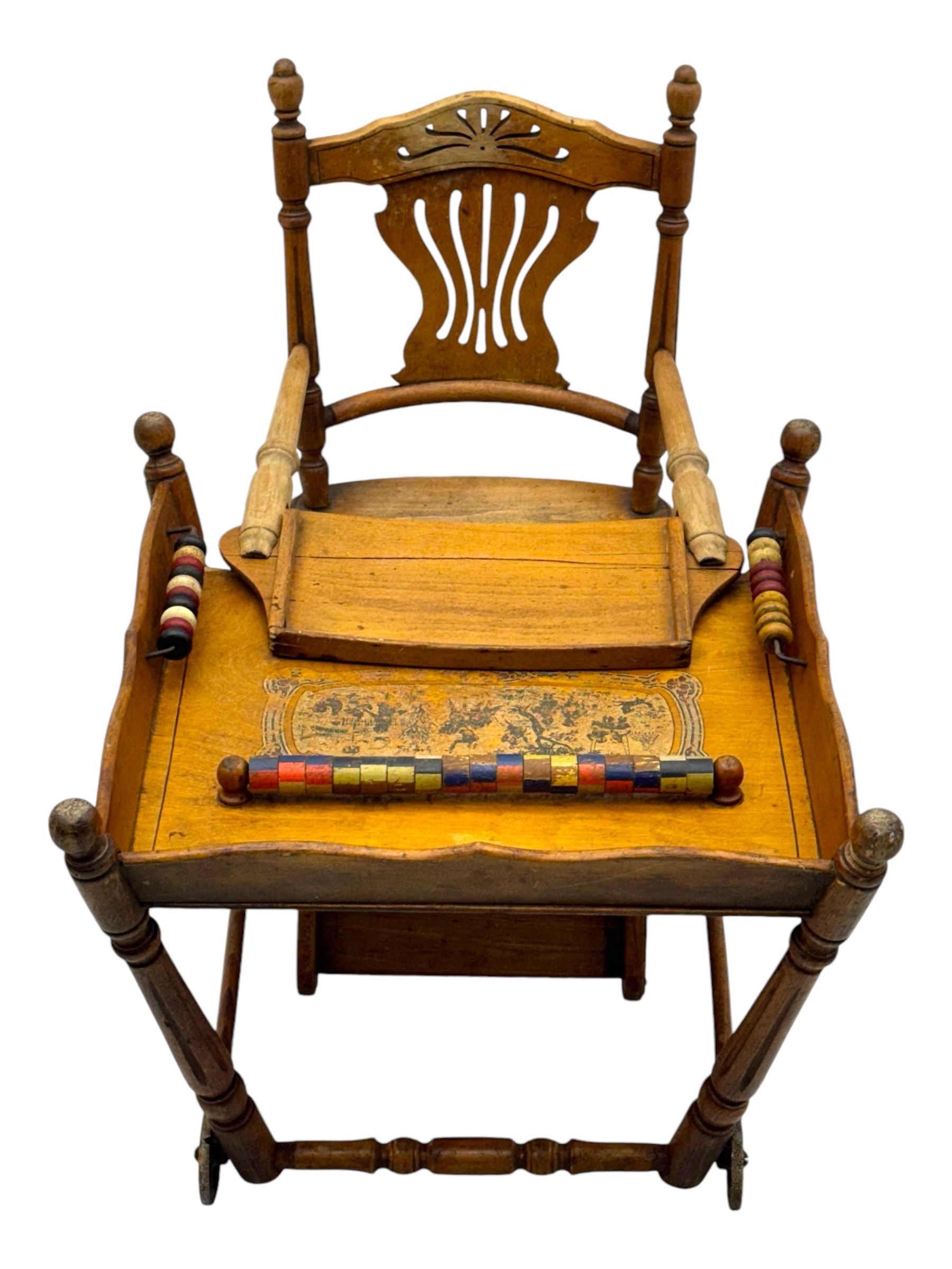 Late 19th century American oak child's metamorphic high chair and play table, carved spindle backrest with pierced splat, detachable tray with abacus and hand painted pastoral decoration, on turned supports with metal wheels