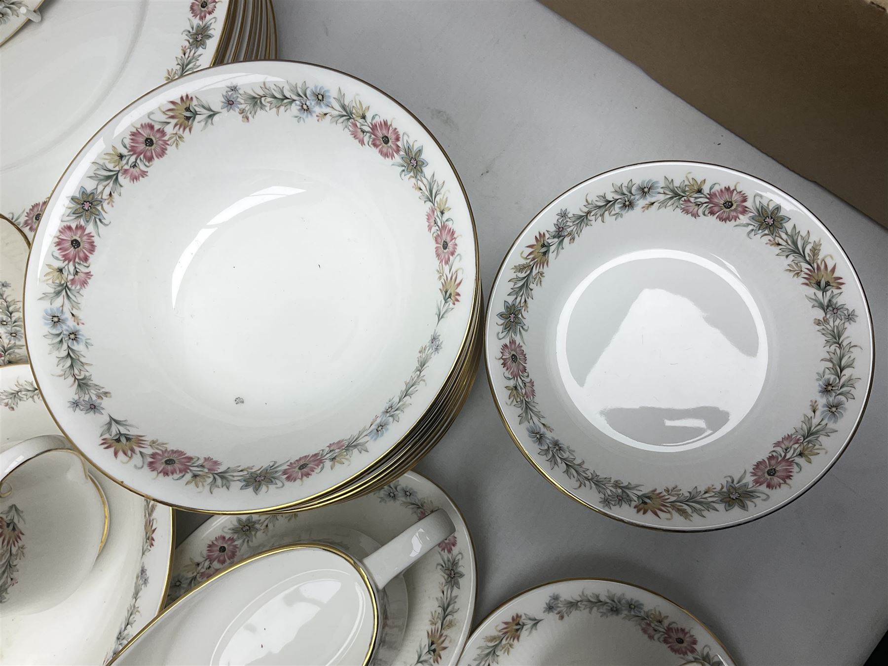 Royal Albert Paragon tea and dinner service for twelve decorated in the Belinda pattern, comprising fourteen saucers, twelve teacups, thirteen side plates, teapot, sauce boat and stand, salt and pepper shakers, two jugs, sucrier, twelve dinner plates, twelve smaller plates, two lidded tureens, twelve bowls, twelve smaller bowls, cake plate, oval plate and oval dish (100)