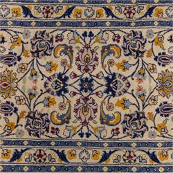 Central Persian Kashan hand-knotted runner, ivory field decorated with an elegant all-over scrolling vine design composed of finely drawn palmettes, floral strays and arabesques in a continuous lattice, principal border on an indigo ground decorated with palmette and vine scroll, flanked by multiple narrow guard stripes, with cotton fringe ends 