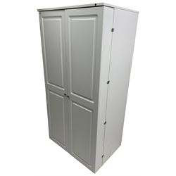 Large white finish sewing cabinet, enclosed by two doors fitted with thread holders and shelves, the interior fitted with shelves and sliding trays, with fold down work surfaces 