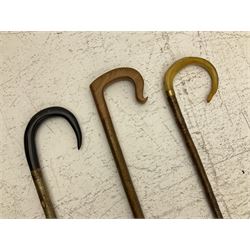 Two smooth polished ram horn handled Shepherd's crooks and a further similar example, together with various shooting sticks, walking sticks and canes, housed in a volcanic lava glaze West German style vase