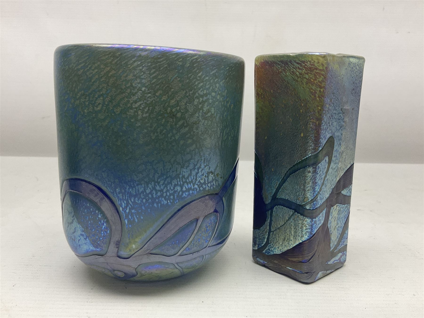 Two Isle of White glass vases, by Alum Bay Glass, both with blue swirl design upon an iridescent mottled blue/green ground, together with a Gozo Glass vase of pebble form, with similar design, H12cm
