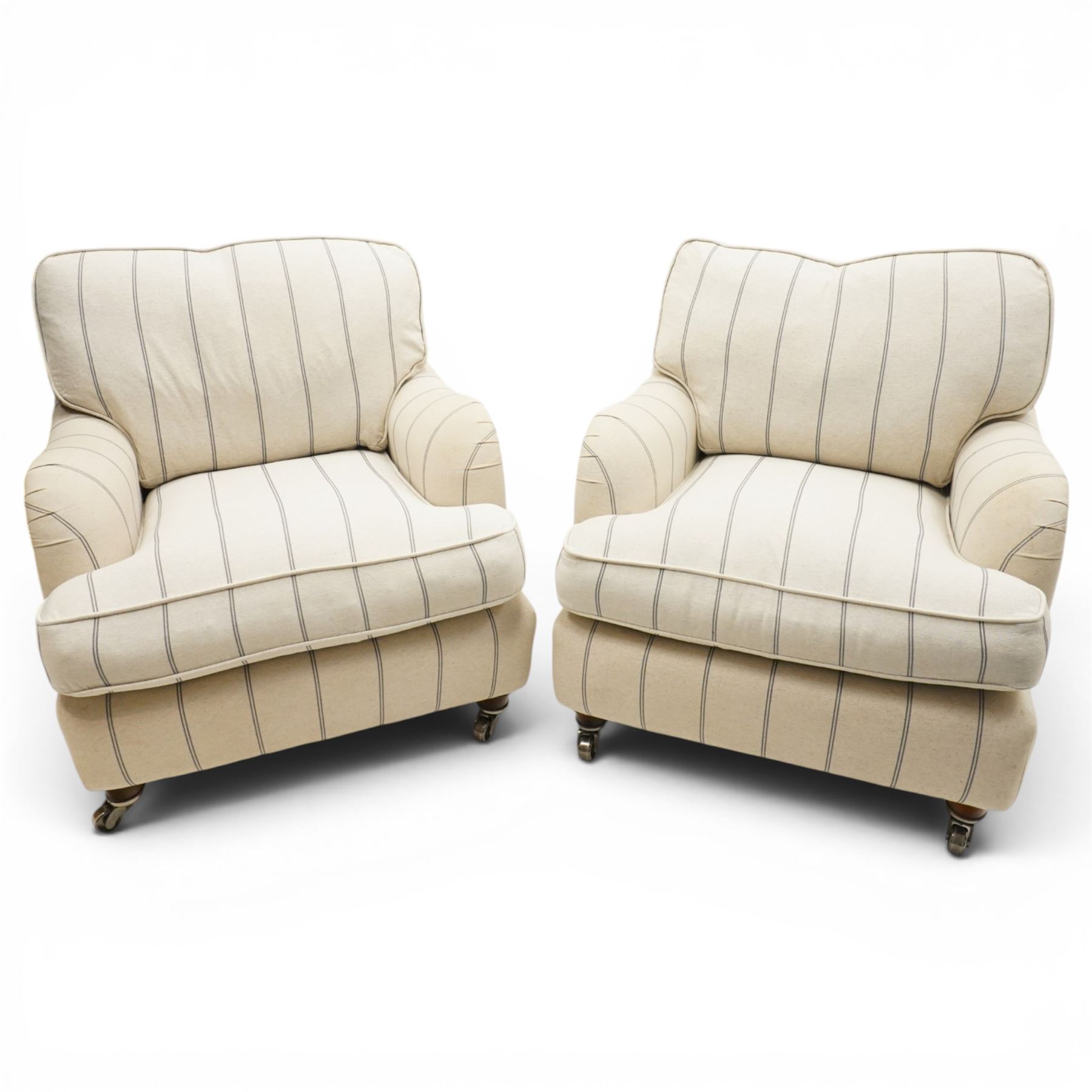 Pair of 20th century Howard shape armchairs, deep seat armchairs in cream and grep striped upholstery, raised on dark supports terminating in front castors