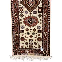 Persian design ivory ground rug, six lozenge medallions within a field of stylised animal and geometric motifs, the guarded border decorated with interconnected S motifs 