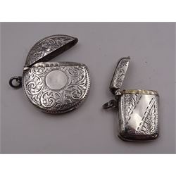 Two early 20th century silver vesta cases, the first example of circular form, with foliate engraved decoration, circular monogramed panel, and lift up cover, hallmarked John Rose, Birmingham 1912, the second example, of typical form, with engraved foliate decoration, and lift up cover, hallmarked Levi & Salaman, Birmingham 1911