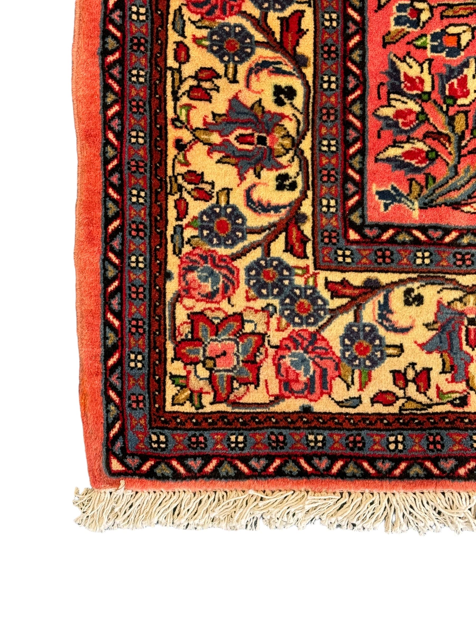 North West Persian Sarouk peach ground rug, the field decorated with floral bunches, pale ground border with repeating flower head motifs within guard stripes 