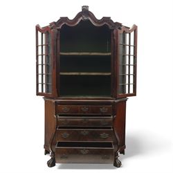 Late 19th century Continental bombe cabinet on chest, shaped moulded cornice with carved cresting, the upper section enclosed by a pair of arched glazed doors with astragal glazing revealing a shelved interior, the lower section fitted with four graduating drawers with rococo-style metal handles, serpentine front and sides, raised on scroll and paw feet