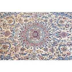Persian Nain ivory ground rug, the busy oval field profusely decorated with scrolling foliate decoration and palmettes in citrine and indigo tones, the central medallion with matching spandrels, the multiple guard bands with repeating stylised quatrefoil motifs and trailing scrolling foliage and flowerheads