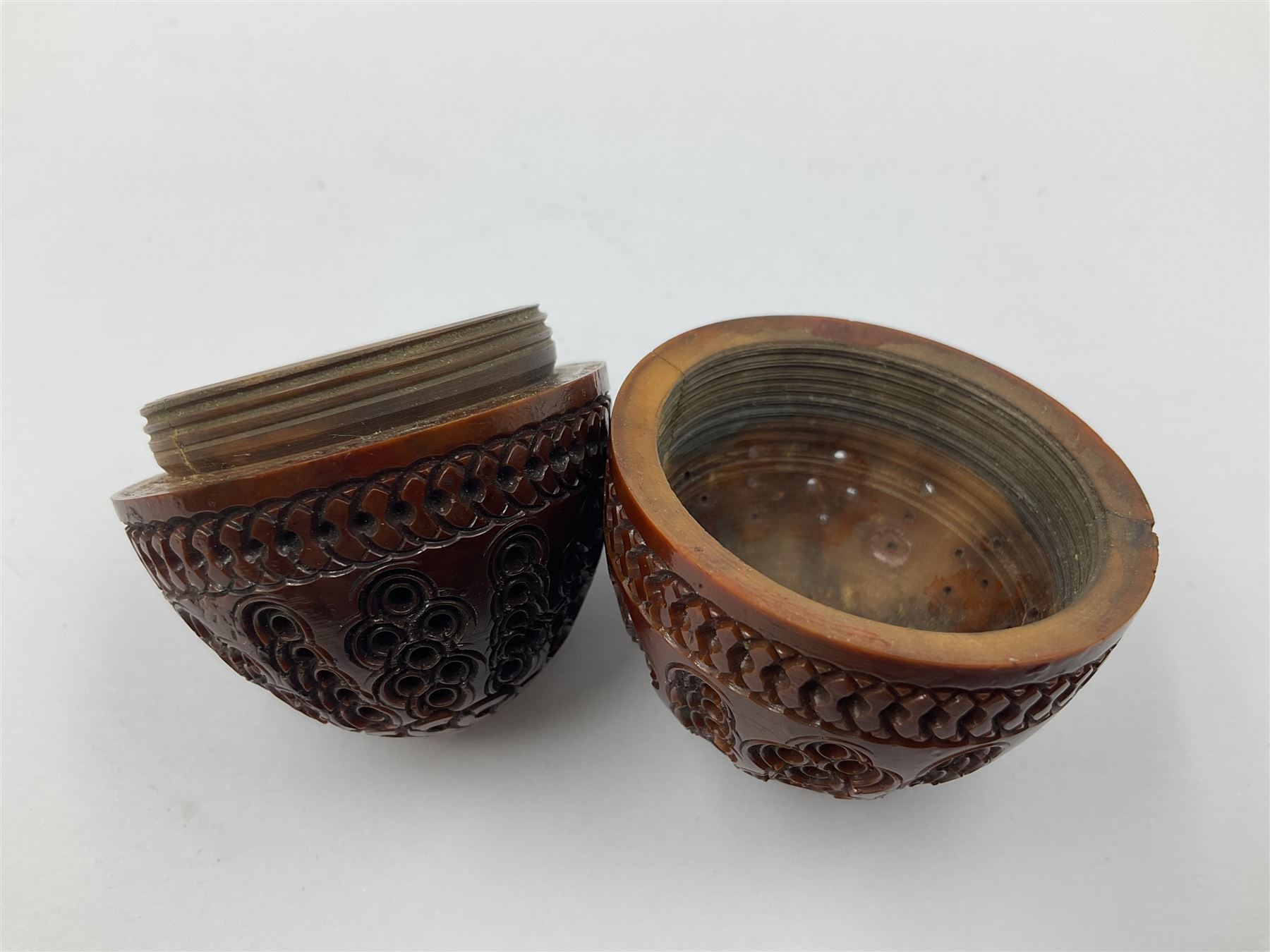Three 19th century coquilla nut pomanders or flea catchers, two of egg shaped form and the third of barrel from with carved and pierced decoration and screw threaded join, largest H8cm