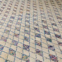 Contemporary Moroccan Berber design wool rug, cream field with blue diamond lattice, decorated with repeating multicoloured lozenge motifs, short fringe ends and bound sides