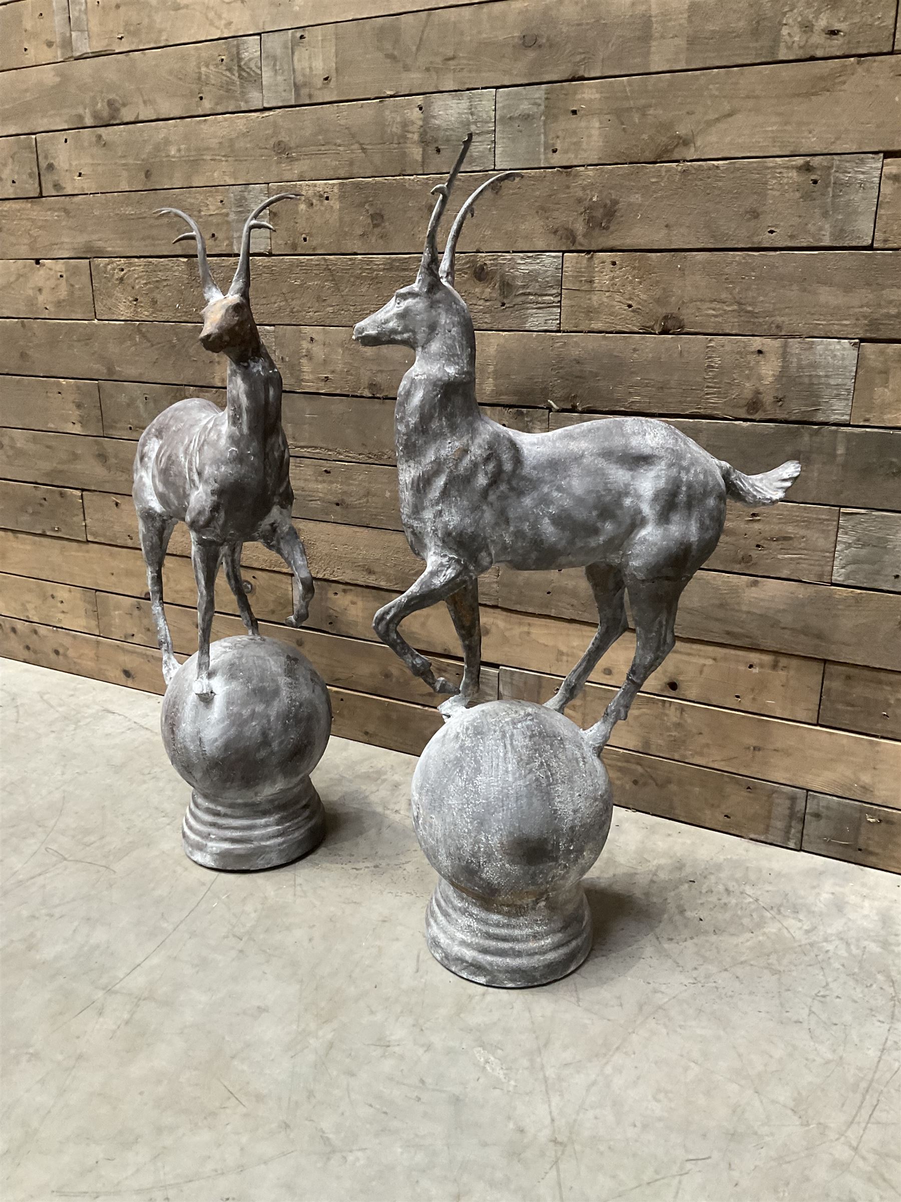 Pair of cast iron garden Stag figures or gate finials, raised on spherical ribbed base 