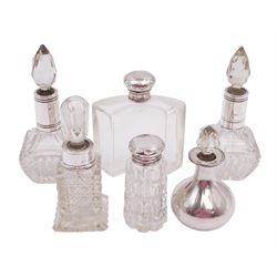 Six silver mounted cut glass dressing table bottles, including a pair with silver collars and a silver covered example with faceted stopper, all stamped or hallmarked, tallest H13cm