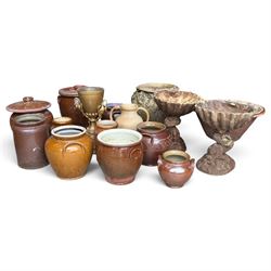 Large assorted collection of glazed stoneware jars and planters, with two lidded crocks, a brass urn and three decorative garden planters, including a pair of shell-form examples