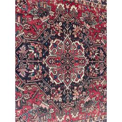 Persian Heriz red ground rug, large medallion decorated with palmettes and Ejder motifs, the border decorated with stylised plant motifs, within floral design guard stripes 
