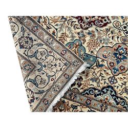 Persian Nain ivory ground rug, wool with silk inlay, the field decorated with stylised gul motifs with palmettes surrounded by interlacing foliate patterns, the guarder border decorated with repeating flower heads and scrolling vines